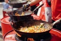 Street food chef cooking noodles and vegetables in a pan on fire at open kitchen. Fried noodles in a wok on the open fire. Asian Royalty Free Stock Photo