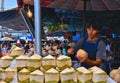 20.08.2017. Street Food Coconut nectar fruit sale with young seller open single coconut for costumer with tourists walking in Chat