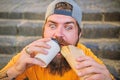 Street food concept. Man bearded eat tasty sausage. Urban lifestyle nutrition. Junk food. Carefree hipster eat junk food Royalty Free Stock Photo