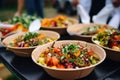 Street food festival, catering service. Vegetable salads in paper plates sold outdoors at market place Royalty Free Stock Photo