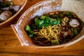 Street food noodles In a tile bowl on the Asian wood floor