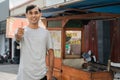 street food seller with walking stall of indonesian Chicken Satay Cooking on a Hot Charcoal Grill