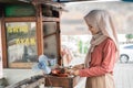 street food seller with walking stall of indonesian Chicken Satay Cooking on a Hot Charcoal Grill