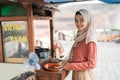 street food seller with walking stall of indonesian Chicken Satay Cooking on a Hot Charcoal Grill