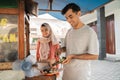 street food seller with walking stall of indonesian Chicken Satay Cooking on a Hot Charcoal Grill