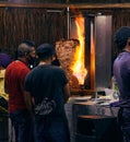 Street food service in Tulum, Mexico at night with people in masks cooking shawarma over a fire