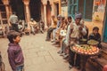 Street food trader and many poor people having fun on narrow street of old city