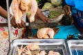 Street food vendor cutting a chicken for a customer in Madagascar