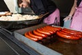 Street food vendor. Grilled sausages on a shop window stall