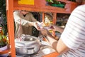 Street food vendor handing a bowl of bakso