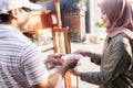 Street food vendor handing a bowl of bakso