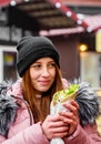 Street food. young woman holding greek meat gyros with tzatziki sauce, vegetables, feta cheese and french fries and eating oudoor Royalty Free Stock Photo