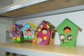 Street of four colorful birdhouses hanging on a yellow wall . Wooden bird`s nest . Wooden birdhouse . Little bird house hanging