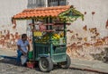 Street fruit vendor with green pushcart, La Antigua, Guatemala