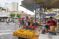 Street fruit vendor weighs bag of fruit for customers in Plaka