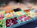 Street Fruits with Steam for Sale. Pomegranate, Watermelon, Kiwi, Mandarin, Pineapple and Steamed Blood Orange in Vapor Fog