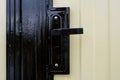 Street gate with corrugated sheet covering and black door knob and lock close-up Royalty Free Stock Photo