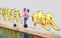 Street graffiti artist painting with a color spray can a graffiti on the wall in the city Royalty Free Stock Photo