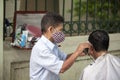 Street hairdressers on the streets of Vietnam. Local street barber cutting on the streets of Hanoi