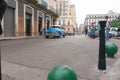 Street in Havana with people and blue Chevrolet classic American vehicle and  old dilapidated buildings Royalty Free Stock Photo