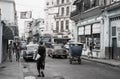 Street in Havana with people walking to and fro, classic American vehicles and old dilapidated buildings Royalty Free Stock Photo