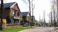 A street with houses and manicured lawns in a typical suburb. Frame made of small brown brick American country houses. Ukraine,