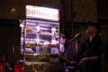 Street karaoke singer and street food seller fish balls. Traditional businesses at night, Bui Vien street. Before Covid-19 Royalty Free Stock Photo