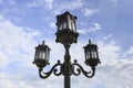 Street lamp against clouds and blue sky.