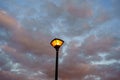 Street lamp on the background sunset dark sky rolled with clouds. Royalty Free Stock Photo