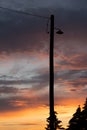 Street lamp on an old wooden telephone pole silhouette under a sunset sky background in Alberta Canada Royalty Free Stock Photo