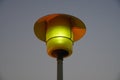 Street Lamp post with the evening skyline view. Outdoor light fixture with sky background. A single hooded street light