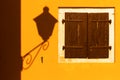 Street lamp shadow on a yellow wall.