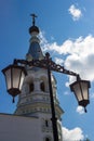 A street lamp and a tent-roofed bell tower of the Russian Orthodox Church in the background Royalty Free Stock Photo