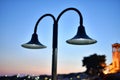 Street lamp with white light shining mysteriously in the sunset of a town