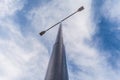 Street lamppost with two searchlights in the daytime against a background of blue sky with white clouds Royalty Free Stock Photo