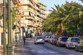 Street landscape of the summer city of Loutraki, Greece, with passing cars and a teenager on a bicycle