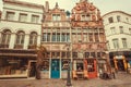 Street lantern and historical reliefs on facades of colorful cafe