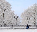 Street lantern with man on the bench cold winter day