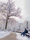 Street lantern with man on the bench cold winter day