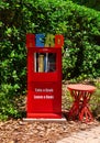 Street library box with sign saying take a book and leave a book with a small bench beside it