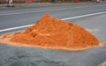 On the street lies a folded pile of sand or red clay. repair of the road of the house backfill gas power line, or reconstruction o