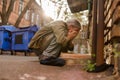 Street life, homeless man squating to wash face. Royalty Free Stock Photo