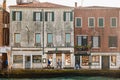 Street life in Venice. People walk along the facade of building next to the waterfront of the lagoon on Giudecca island