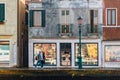 Street life in Venice. People walk along the facade of building next to the waterfront of the lagoon on Giudecca island