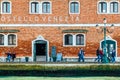 Street life in Venice. People walk along the facade of building next to the waterfront of the lagoon on Giudecca island
