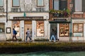 Street life in Venice. People walk along the facade of building next to the waterfront of the lagoon on Giudecca island