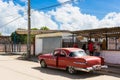 Street life view with a american red Chrysler classic car before a street shop in Santa Clara Cuba - Serie Cuba Reportage