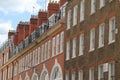 Street light hangs over brick buildings, a classic white clock, and a black building in London Royalty Free Stock Photo