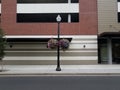 Street light or lamp with hanging flower pots or baskets with colorful flowers