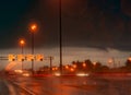 Street light at night in rainy day. Car and truck on asphalt road. Dark night at highway with electric lamp light and speed limit Royalty Free Stock Photo